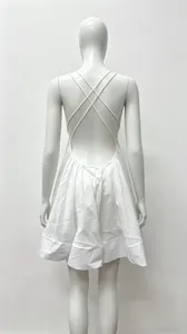 Detail showing the elegant backless design with cross-back straps of the white dress
