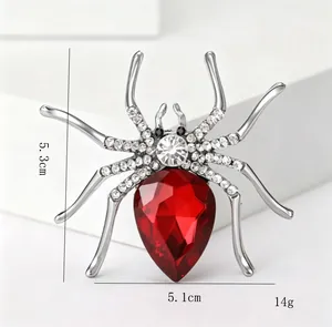 Detail view of silver spider brooch with red gemstone and dimensions 5.3cm by 5.1cm