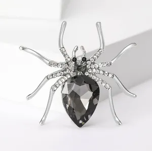 Sparkling spider brooch with dark grey pear-shaped gemstone and rhinestones