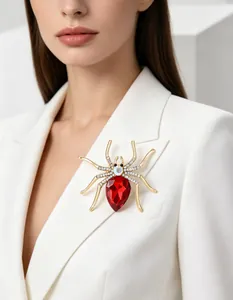 Macro shot of spider brooch with red pear-shaped gemstone and rhinestones on suit