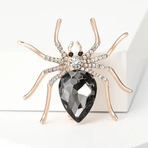 Sparkling spider brooch in rose gold alloy with grey gemstone on a white pedestal