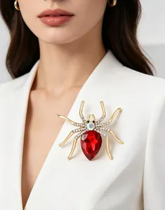 Macro shot of a spider brooch with red gemstone and rhinestones on a white blazer