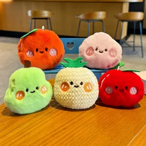 Five styles of cute fruit plush keychains including peach and apple on a wooden desk