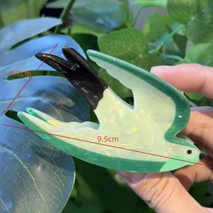 Dettaglio della pinza per capelli a rondine in acetato verde con dimensioni