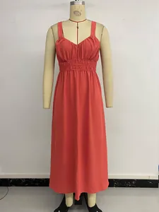 Détail d'une robe d'été orange corail avec taille smokée et décolleté en V élégant