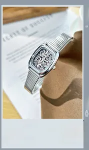 Détail d'une montre carrée argentée avec cadran léopard et chiffres romains sur tissu