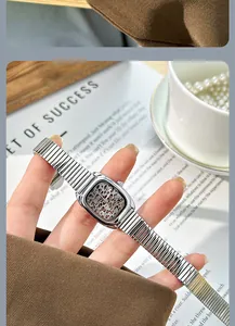 Détail d'une montre vintage avec cadran léopard et bracelet chaîne serpent argent