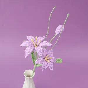 Handmade crochet purple lily bouquet in white ceramic vase on purple background