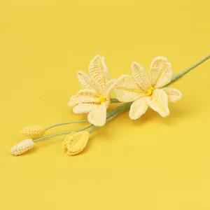 Handmade crochet yellow lily bouquet flower with green stem on bright yellow background