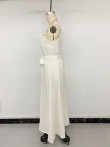 Detail of white sleeveless dress showing lace applique on shoulder and waist tie