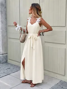 Detail of white floral shoulder applique and waist tie on the slit summer dress
