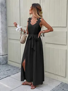Close-up of black sleeveless maxi dress featuring intricate lace flower appliques on straps