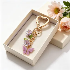 Porte-clés papillon et fleurs colorées avec fermoir cœur doré dans un coffret cadeau