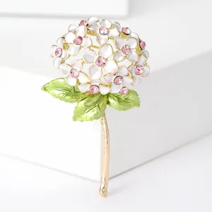 Macro detail of enamel hydrangea brooch with pink crystal and golden stem