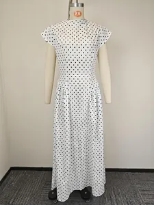 Dettaglio del vestito lungo bianco a pois con scollo rotondo e vita plissettata