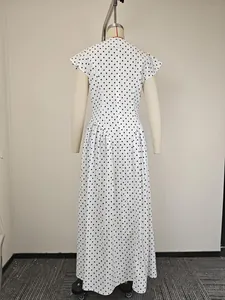 Dettaglio dell'abito bianco a pois con scollo a V sulla schiena e orlo ampio svasato