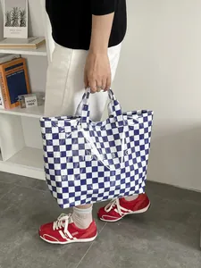 Detail of blue and white checkered waterproof tote bag with printed lettering