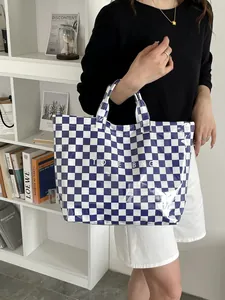Detailed view of the blue and white checkered glossy tote bag with white lettering