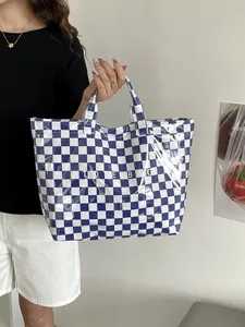 Detail of blue and white checkered tote bag with waterproof glossy finish and text