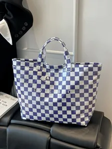 Detailed view of large purple and white checkered tote bag with polished finish