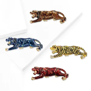 Vibrant tiger brooches in four enamel finishes on minimalist white display stands