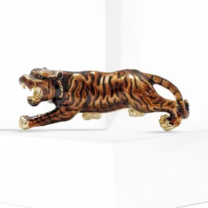 Macro detail of enamel tiger brooch with gold alloy texture on a white stand
