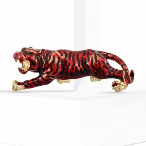 Detailed view of roaring tiger brooch with red enamel and gold-tone metal accents