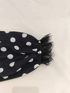 Detail of elastic cuff with black eyelash lace trim on a polka dot vintage dress