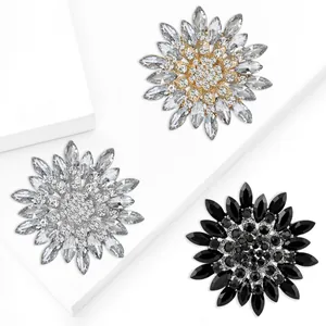 Spille a girasole scintillanti in oro, argento e nero su supporti geometrici moderni