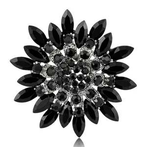 Elegante spilla a girasole argentata con cristalli neri marquise su sfondo bianco