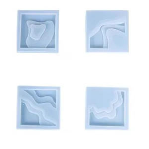 Set of four light blue square silicone molds for DIY resin coasters with wave patterns