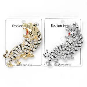 Detail of silver and gold tiger brooches with sparkling crystals and red accents