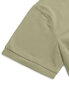 Detail view of sage green linen polo shirt showing ribbed cuffs and fabric texture