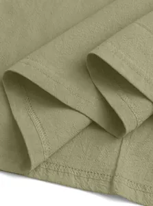 Detailed macro view of olive green linen fabric texture and double-stitch hem sewing