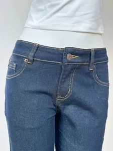 Detailed view of dark blue flare jeans featuring brand metal button and contrast stitching