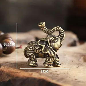 Vue macro d'une statuette d'éléphant en laiton vintage avec gravures et dimensions
