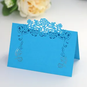 Detail of laser-cut rose hollow pattern on blue paper wedding table place card