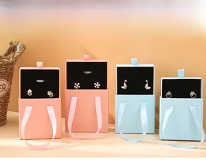Drawer jewelry boxes in pink and blue with silk ribbon handles and black flocking lining