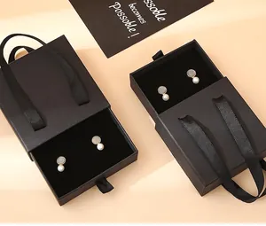 Detail of black drawer jewelry box with ribbon handle and velvet sponge lining