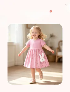 Détail d'une robe d'été rose en coton avec patch lapin blanc et imprimé floral