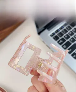 Macro detail of rectangle iridescent pink hair claw clip with pearlescent finish
