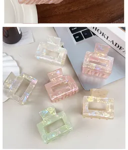 Close-up of rectangular hair claws with iridescent marble textures in various colors