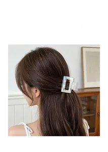 Close-up of holographic mermaid-style hair claw clip on model's brown hair
