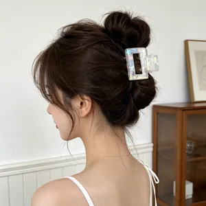 Iridescent rectangular shark hair claw clip styled on a woman's hair in home setting