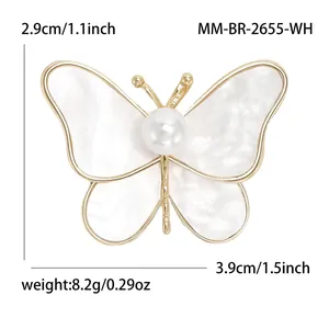 Elegant gold butterfly brooch with white shell wings and a central pearl, 3.9cm width