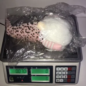 Detailed view of the Christmas sequin gnome plush weight being measured on a scale