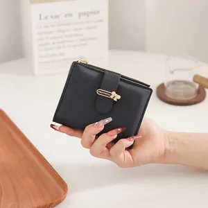 Close-up of black PU leather short wallet with golden bow buckle and zip coin pocket