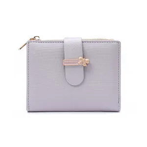 Close-up of lilac purple short wallet with golden bow and metal clasp detail