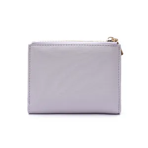 Detailed macro shot of light purple fabric wallet with gold zipper and textured surface