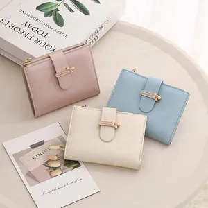 Detailed view of pink, blue and white PU leather wallets with elegant metal clasps